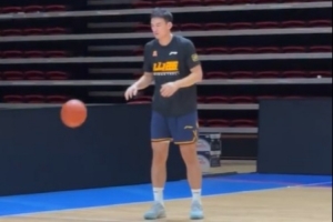 刘东身着山西训练服，在训练师的指导下进行投篮练习。